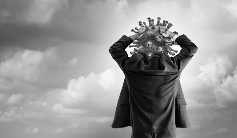 Person in business suit with virus particle replacing head against cloudy sky
